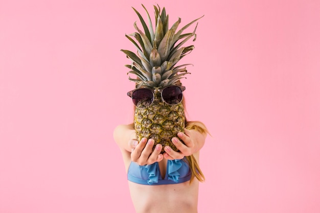 Girl in bikini showing pineapple