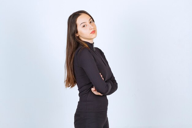 Girl in black clothes giving professional and neutral poses without reaction. 