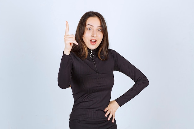 Girl in black clothes looks thoughtful and doubtful. 