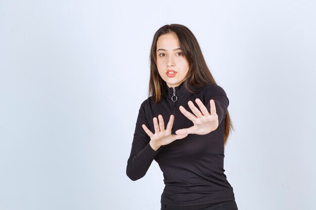 Girl in black clothes trying to stop something. 