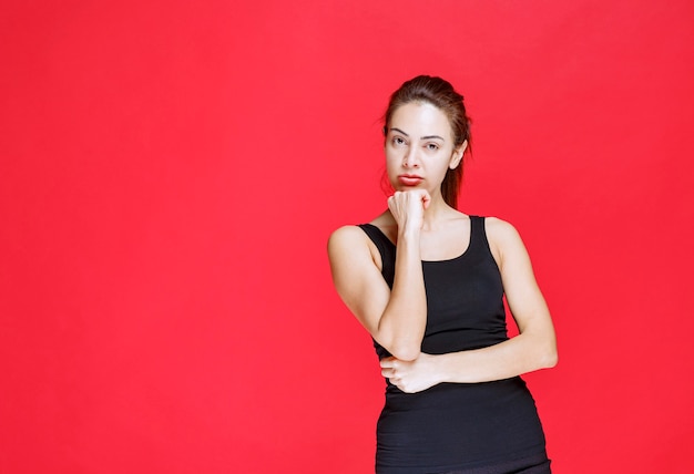 Girl in black shirt feeling positive and smiling gently. High quality photo