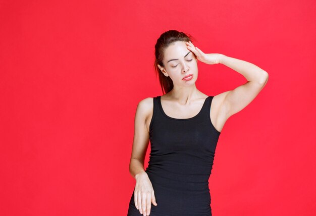 Girl in black shirt is tired and sleepy. High quality photo