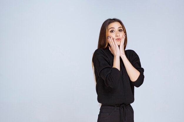 Girl in black shirt looks confused and excited. High quality photo