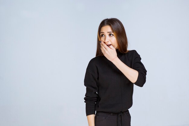 Girl in black shirt looks thrilled and scared. High quality photo