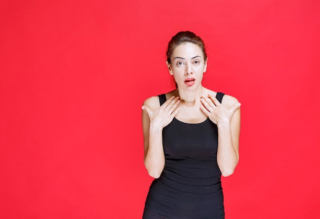 Free photo girl in black shirt pointing at herself. high quality photo