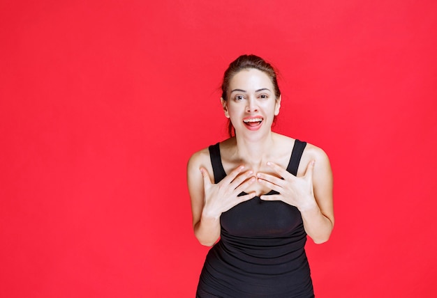 Free photo girl in black shirt pointing at herself. high quality photo