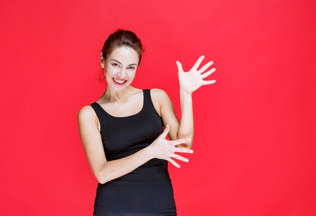 Girl in black shirt pointing at something on the right. High quality photo