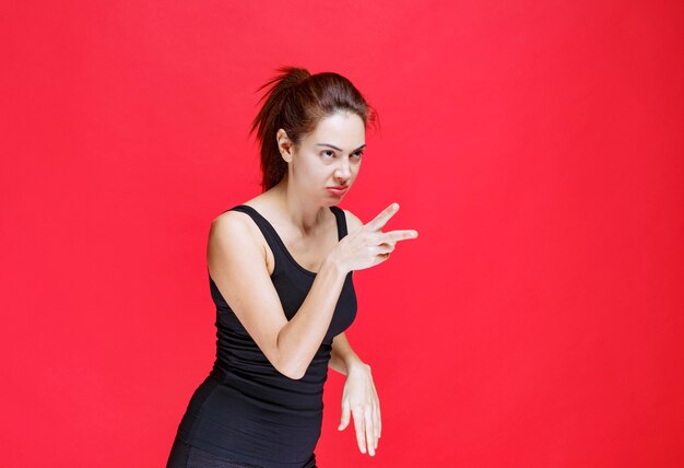 Girl in black shirt pointing at something on the right. High quality photo