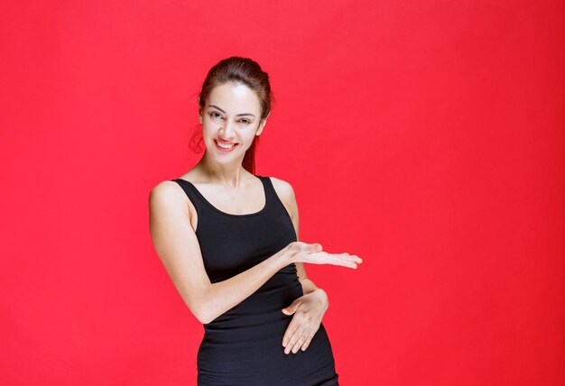 Girl in black shirt pointing at something on the right. High quality photo