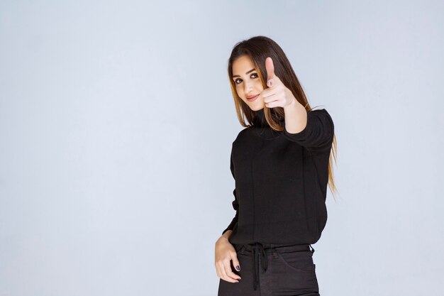 Girl in black shirt showing positive hand sign. High quality photo