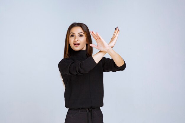 Girl in black shirt stopping and preventing something. High quality photo