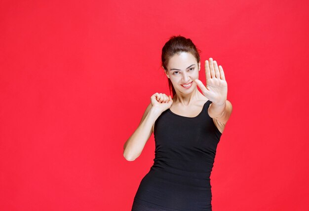 Girl in black shirt trying to stop danger coming to her. High quality photo