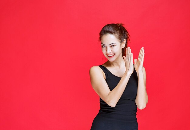 Girl in black sport shirt applauding a performance. High quality photo