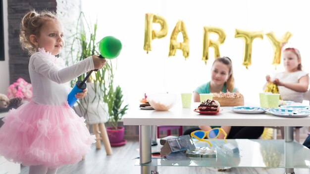 Girl blowing balloons on birthday party