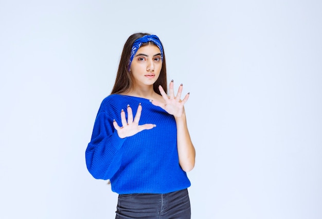 Girl in blue shirt looks scared and terrified.