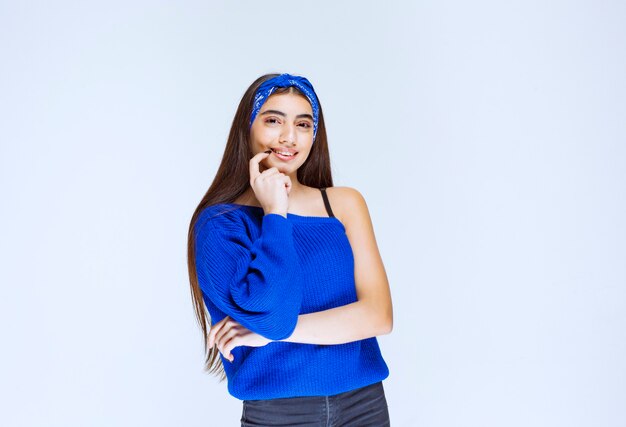 Girl in blue shirt thinking and analyzing.