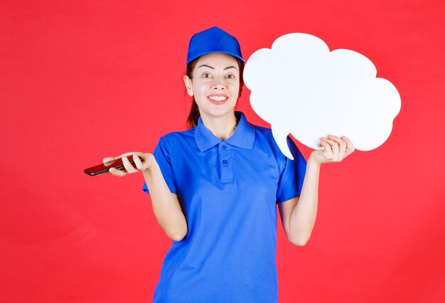 青いユニフォームとベレー帽の女の子は、白い空白の思考ボードを保持し、オンライン会議を行うか、音声メッセージを送信します。