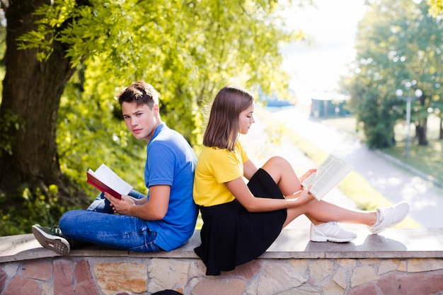 Girl and boy reading in park