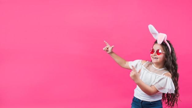 Girl in bunny ears pointing away