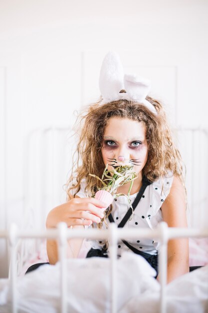 Girl in bunny ears tasting plant