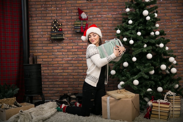 Girl by the Christmas tree unpacking gifts