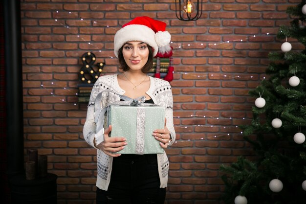 Girl by the Christmas tree unpacking gifts