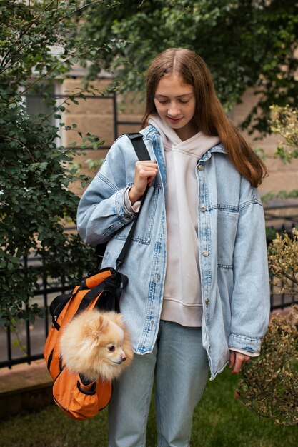 Girl carrying puppy in bag front view