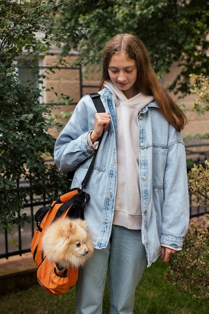 無料写真 バッグの正面図で子犬を運ぶ女の子