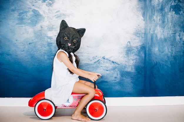 Free photo girl in cat mask on car