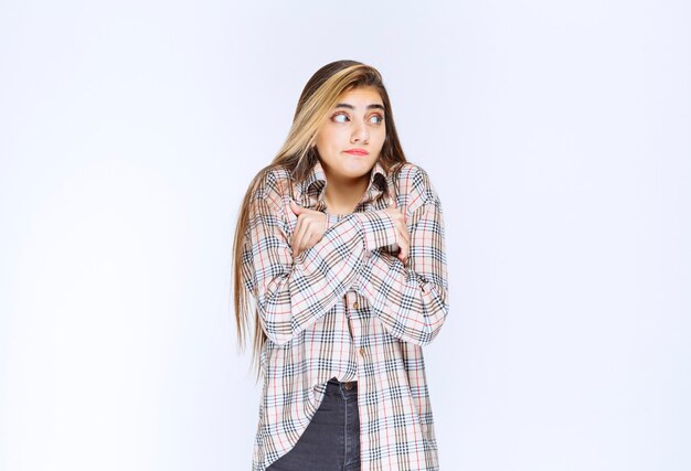 Girl in checked shirt crossing arms and feeling cold