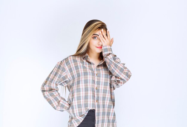 Girl in checked shirt looking across her fingers