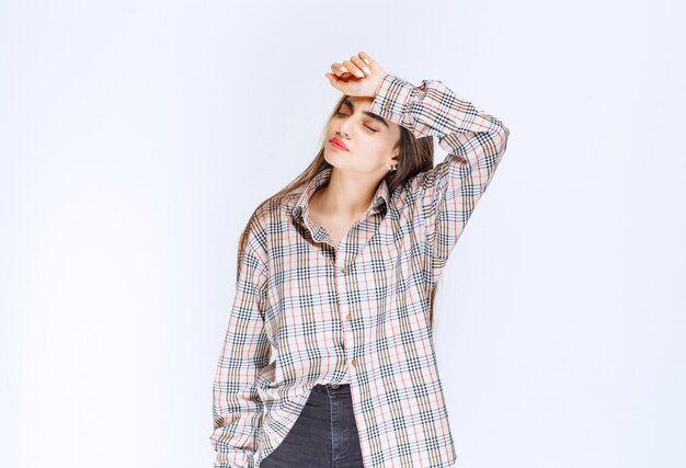 Girl in checked shirt looks pale and sleepy