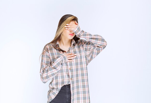 Girl in checked shirt looks pale and sleepy