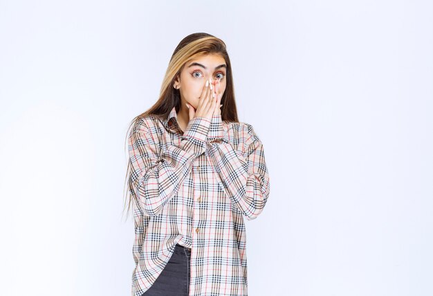 Girl in checked shirt looks scared and terrified