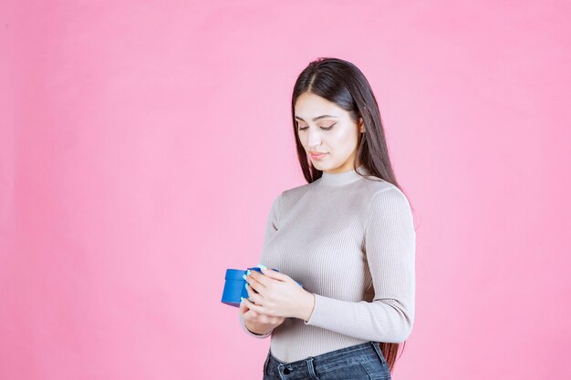 Girl checking her blue gift box and looking excited and surprized