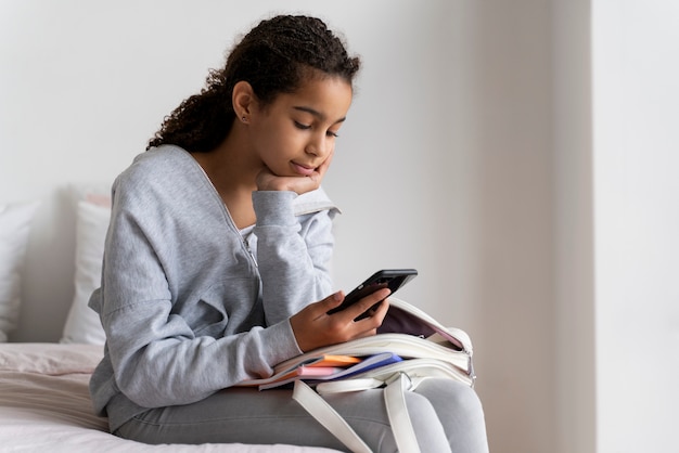 Foto gratuita ragazza che controlla il suo telefono prima della scuola