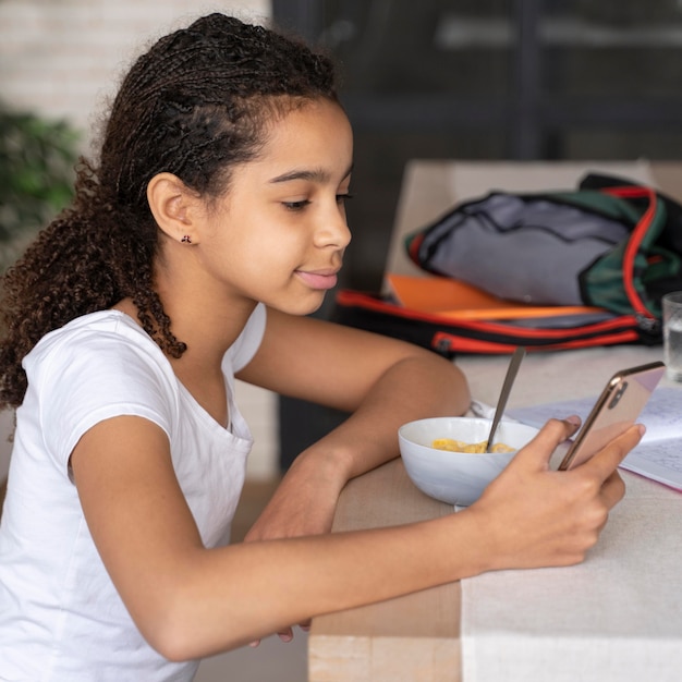 Girl checking her phone while having breakfast