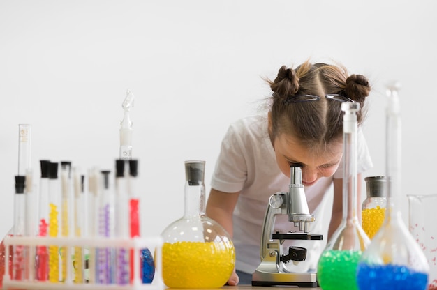 Девушка проверяет микроскоп в лаборатории
