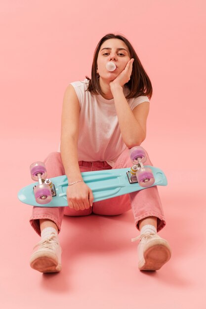 Girl chewing gum and holding skateboard