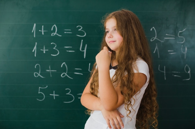 Girl in class thinking and smiling