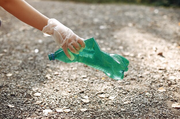 Girl collects garbage in garbage bags in park