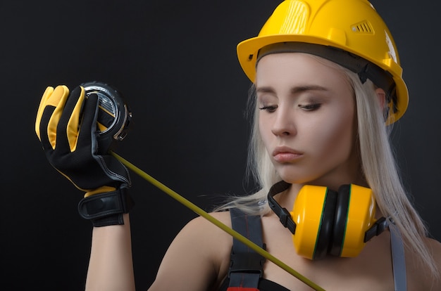 The girl in a construction firm works with a tape measure