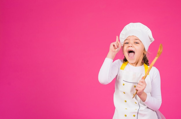 Girl cook with ladle showing index finger 