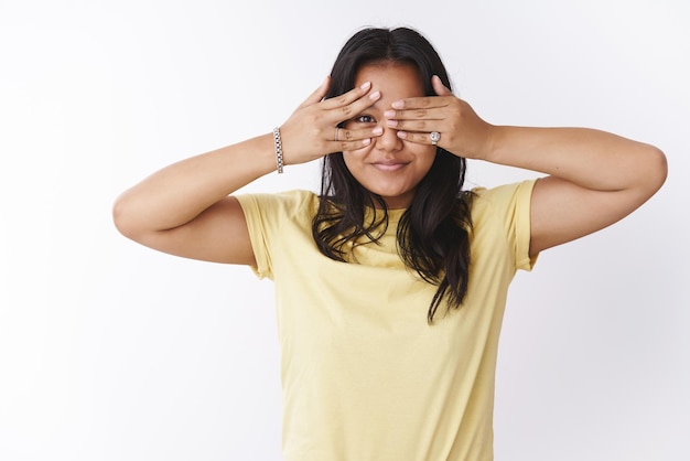 Free photo girl cover eyes, peeking through fingers  smiling