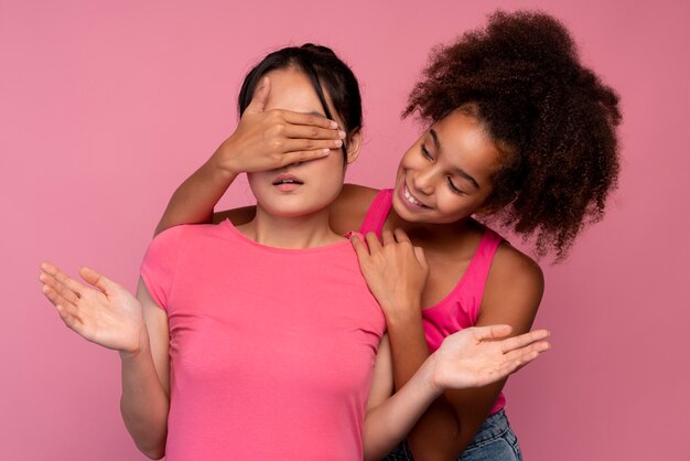 Girl covering her best friends eyes