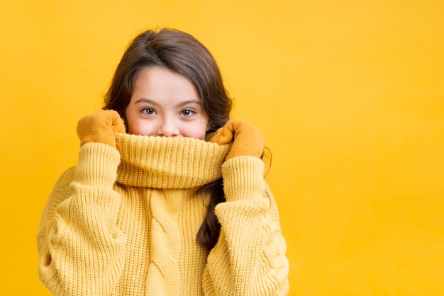 Girl covering her mouth with her sweater