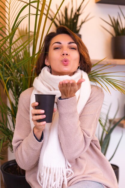 A girl in a cozy cafe warms herself up with a cup of hot coffee