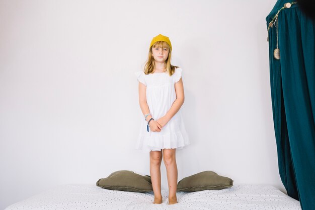 Girl in crown standing on bed