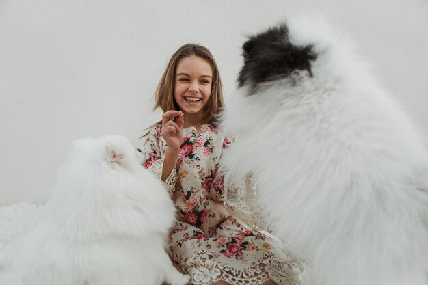 フェッチを再生する女の子とかわいい白い子犬