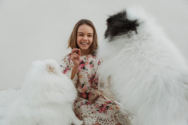 Girl and cute white puppies playing fetch